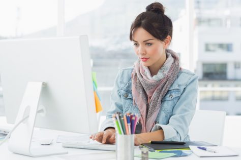 Woman working at a computer having a positive user experience with accessible PDFS.