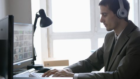 Man in front of a laptop using assistive technology to read accessible digital financial information
