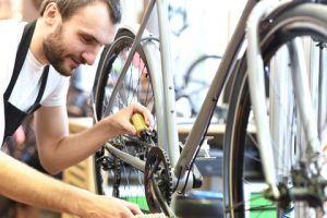 Man working at a bicycle shop facing third quarter accessibility lawsuits