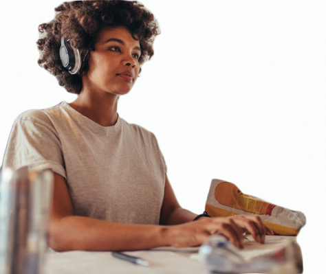 Woman who is able to use her computer wearing headphones thanks to digital accessibility.