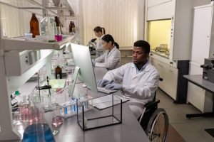 Diversity and inclusion example photo: Man in a wheelchair working in a lab alongside colleagues