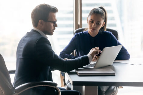 Two people conferring over a laptop